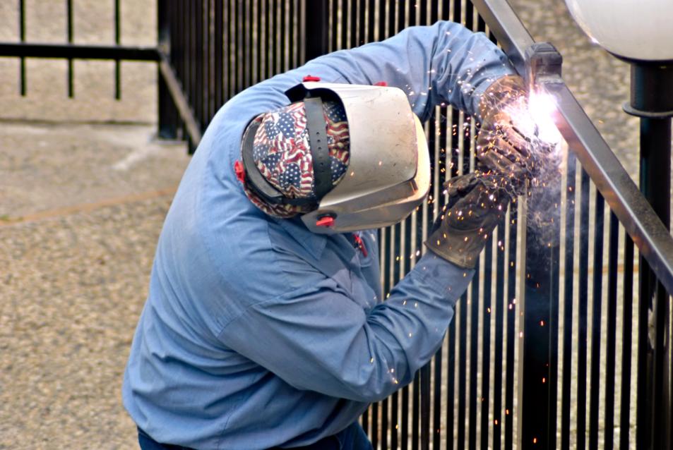 fence-installation-worker-welds-a-seal-on-a-new-fence-